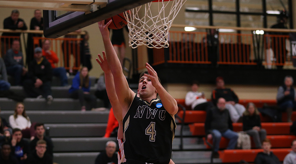 Nate Bahe finishes a layup for Nebraska Wesleyan with a Wartburg defender trailing. (Photo by Ryan Coleman, d3photography.com)