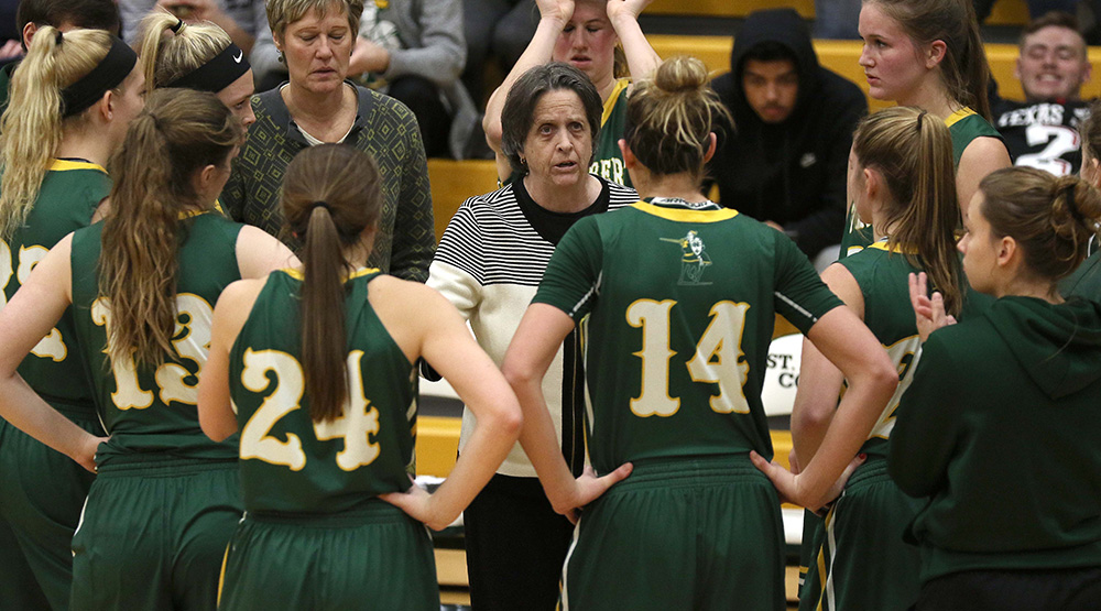 Connie Tilley with her St. Norbert women's basketball players during a 30-second timeout. (St. Norbert athletics photo)