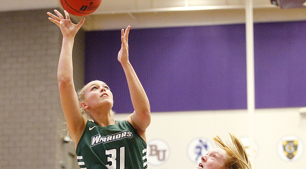 Wisconsin Lutheran's Amanda Brug goes up over an Illinois Wesleyan defender for two in a first-round NCAA Tournament game at St. Thomas. (Photo by Caleb Williams, d3photography.com)